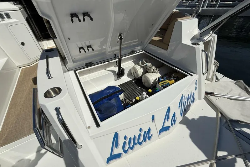  Yacht Photos Pics 2013 Cruisers Yachts Cantius storage compartment with boating equipment and "Livin' La Vida" text.