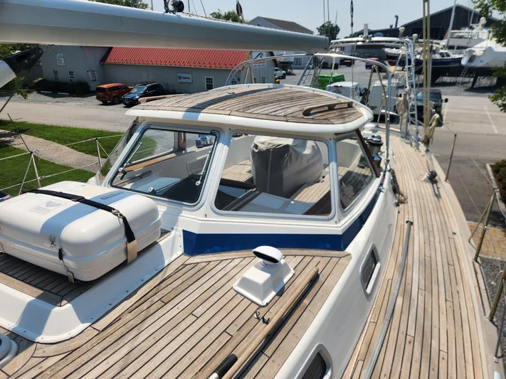 Sonder Yacht Photos Pics 2003 Hallberg-Rassy 46 sailboat with wooden deck and cabin, docked at a marina.