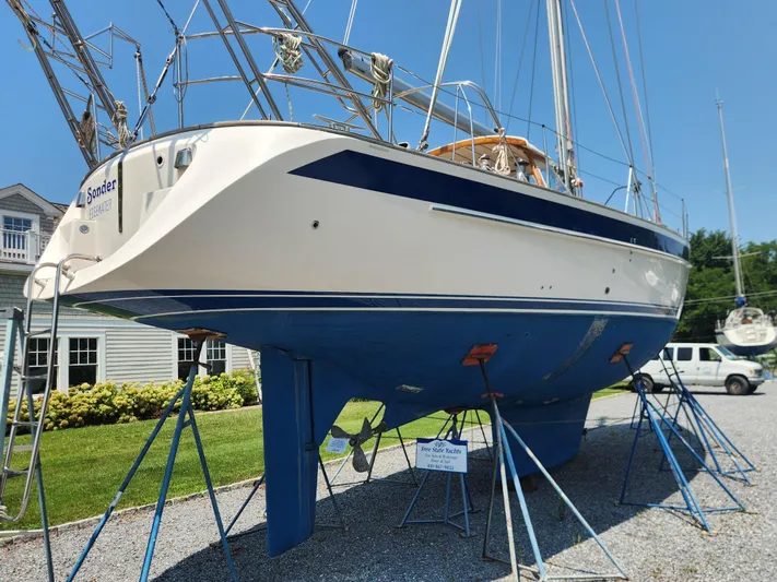 Sonder Yacht Photos Pics 2003 Hallberg-Rassy 46 sailboat on stands, blue hull, sunny day, marina background.