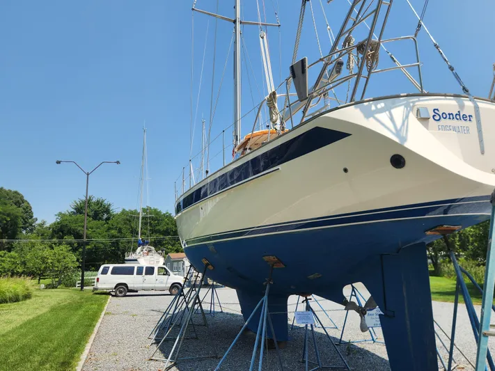 Sonder Yacht Photos Pics 2003 Hallberg-Rassy 46 sailboat on stands, clear sky, parked van nearby.