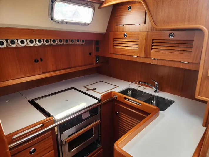 Sonder Yacht Photos Pics Luxurious 2003 Hallberg-Rassy 46 yacht kitchen with wood cabinetry and modern appliances.