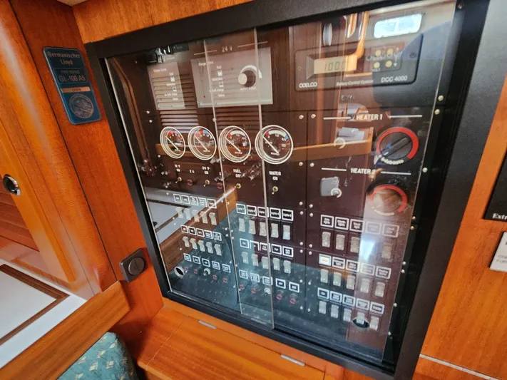 Sonder Yacht Photos Pics Electrical control panel inside a 2003 Hallberg-Rassy 46 yacht, featuring gauges and switches.