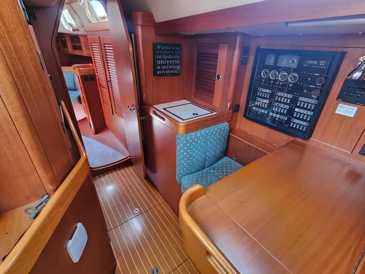 Sonder Yacht Photos Pics Interior of 2003 Hallberg-Rassy 46 yacht with wood paneling and control panel.