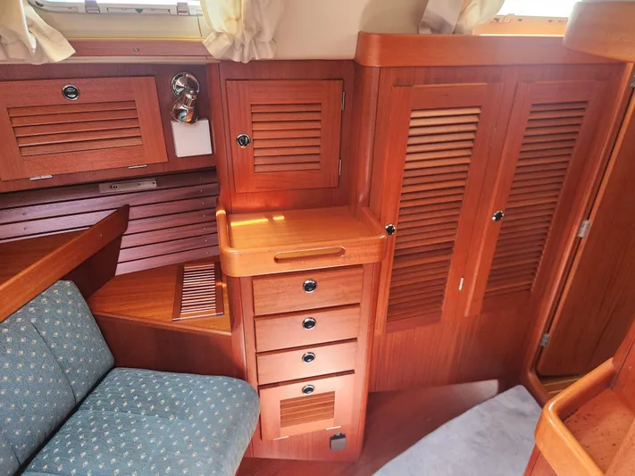Sonder Yacht Photos Pics Interior of 2003 Hallberg-Rassy 46 yacht with wooden cabinetry and upholstered seating.