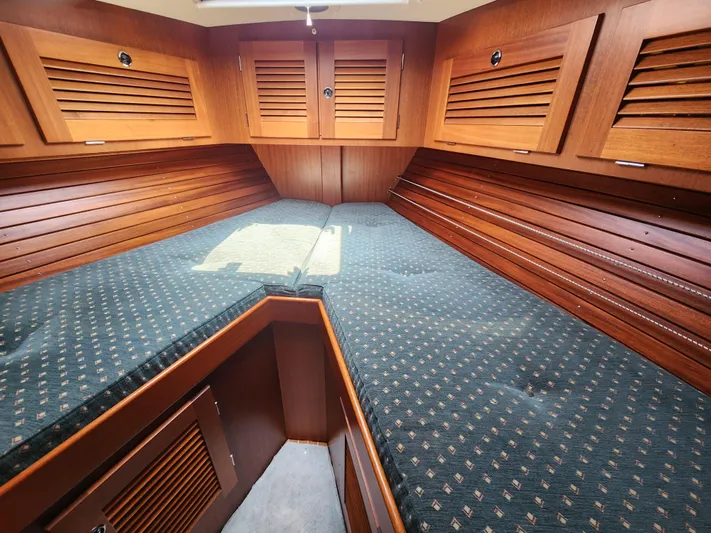 Sonder Yacht Photos Pics Interior cabin of 2003 Hallberg-Rassy 46 yacht with wooden finish and cushioned bed.