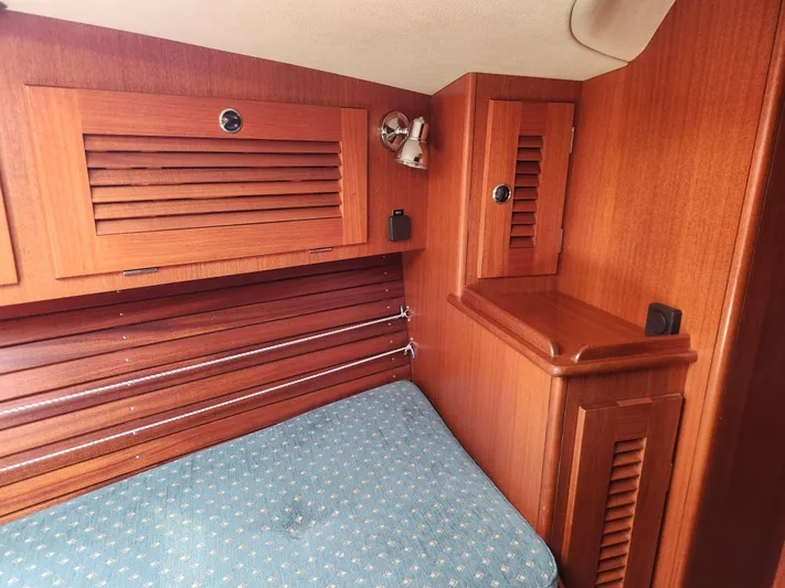 Sonder Yacht Photos Pics Hallberg-Rassy 46 (2003) yacht interior with wooden cabinetry and blue cushioned seating.