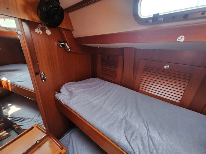 Sonder Yacht Photos Pics Cozy cabin interior of 2003 Hallberg-Rassy 46 sailboat with wooden finish and bunk beds.