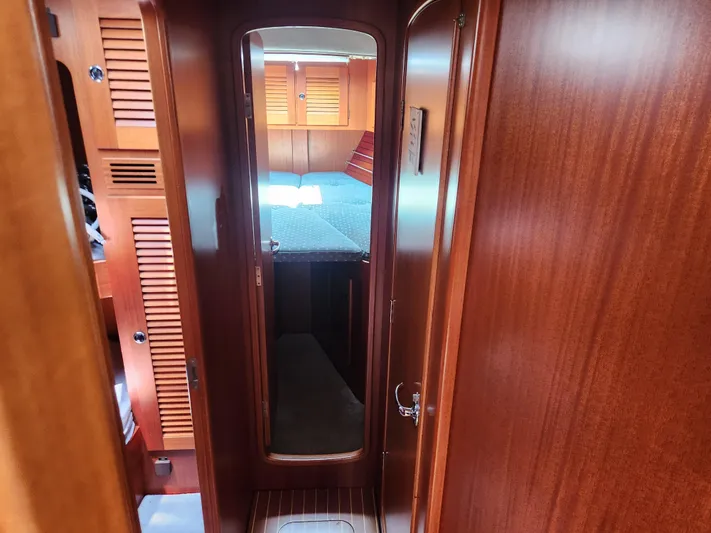 Sonder Yacht Photos Pics Interior of 2003 Hallberg-Rassy 46 yacht, featuring wooden cabinetry and cozy sleeping quarters.