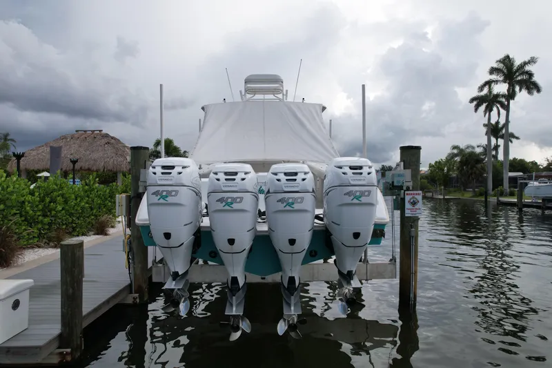  Yacht Photos Pics 2009 Yellowfin 42 Offshore boat with four powerful outboard engines docked by palm trees.