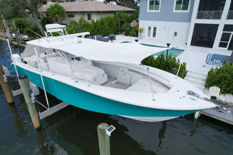  Yacht Photos Pics 2009 Yellowfin 42 Offshore boat docked by a modern waterfront home.