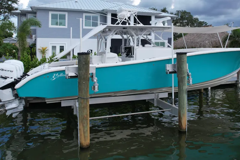  Yacht Photos Pics 2009 Yellowfin 42 Offshore boat docked near a waterfront house.