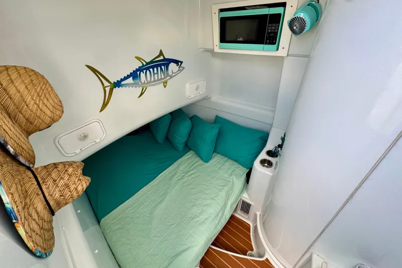  Yacht Photos Pics Cozy cabin interior of 2009 Yellowfin 42 Offshore with teal bedding and wall art.