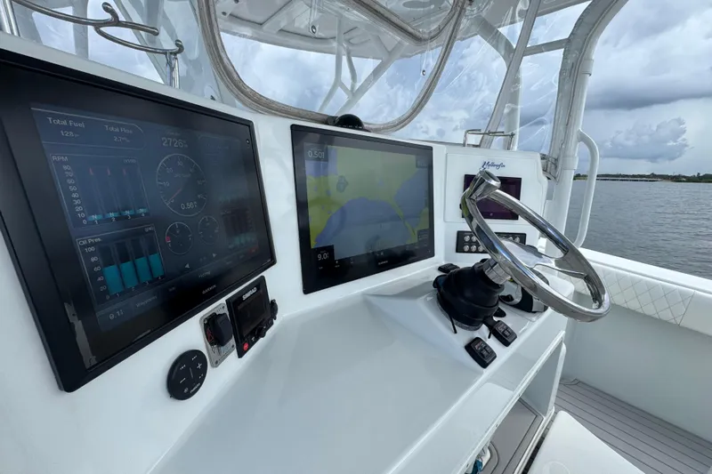  Yacht Photos Pics 2009 Yellowfin 42 Offshore boat dashboard with navigation screens and steering wheel.