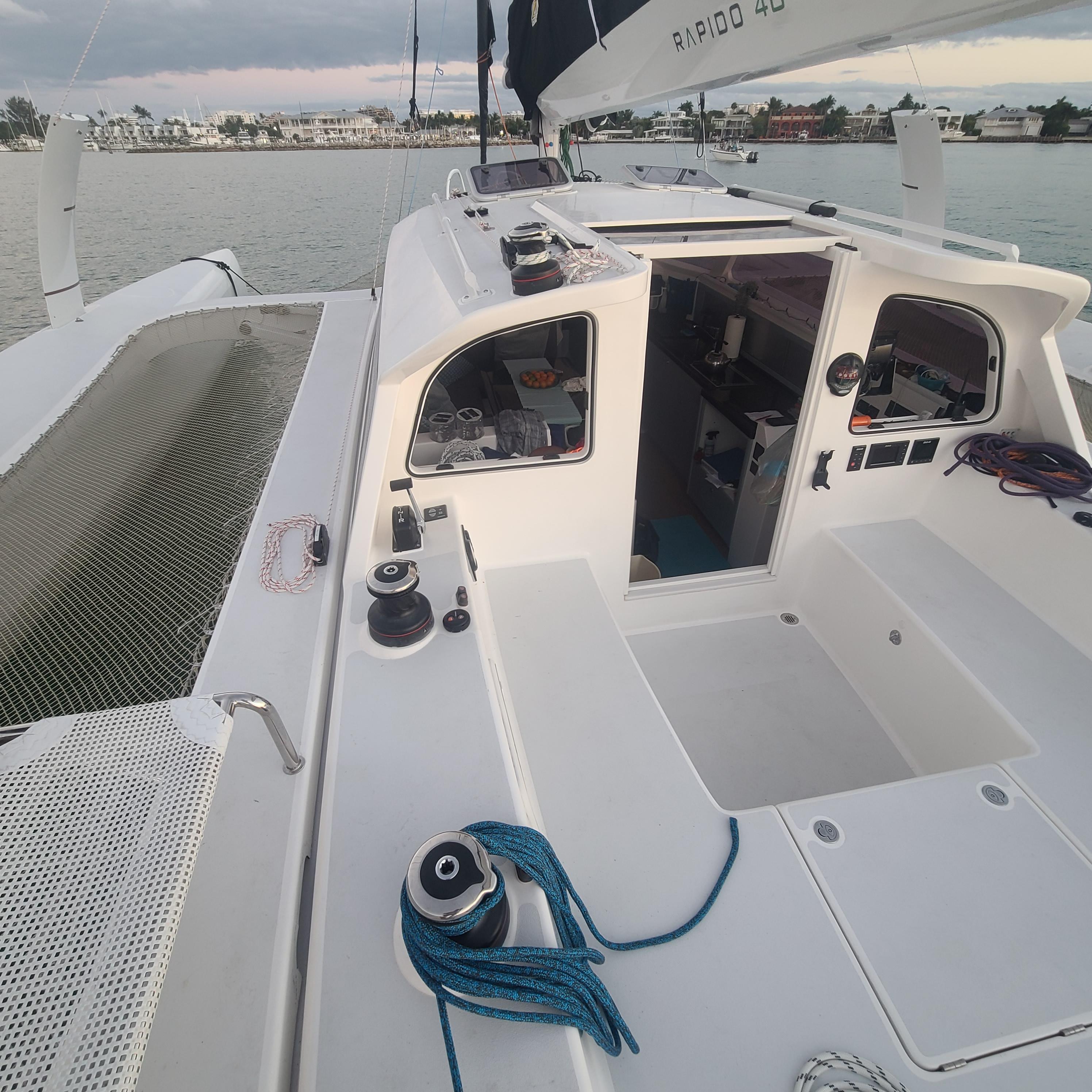 2025 Rapido 40 sailboat deck with open cabin, moored by the shore.