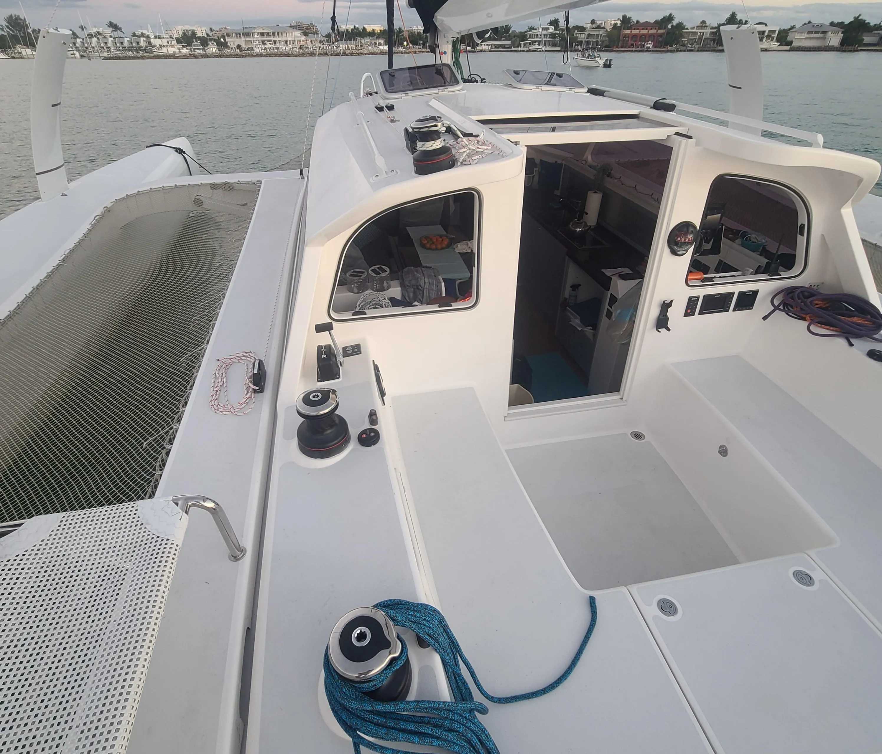 2025 Rapido 40 sailboat deck with open cabin, moored by the shore.