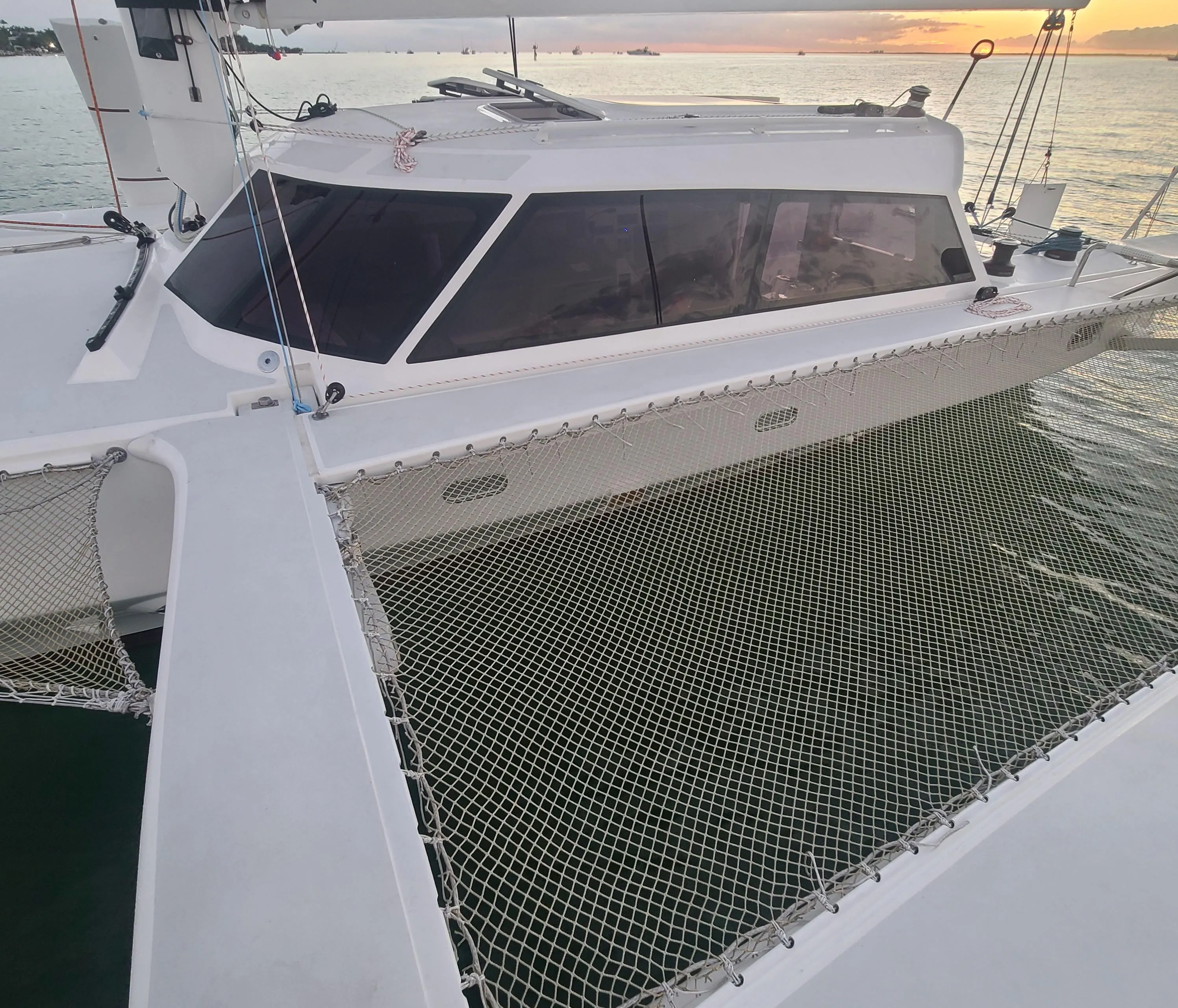 2025 Rapido 40 catamaran with netting, docked at sunset.
