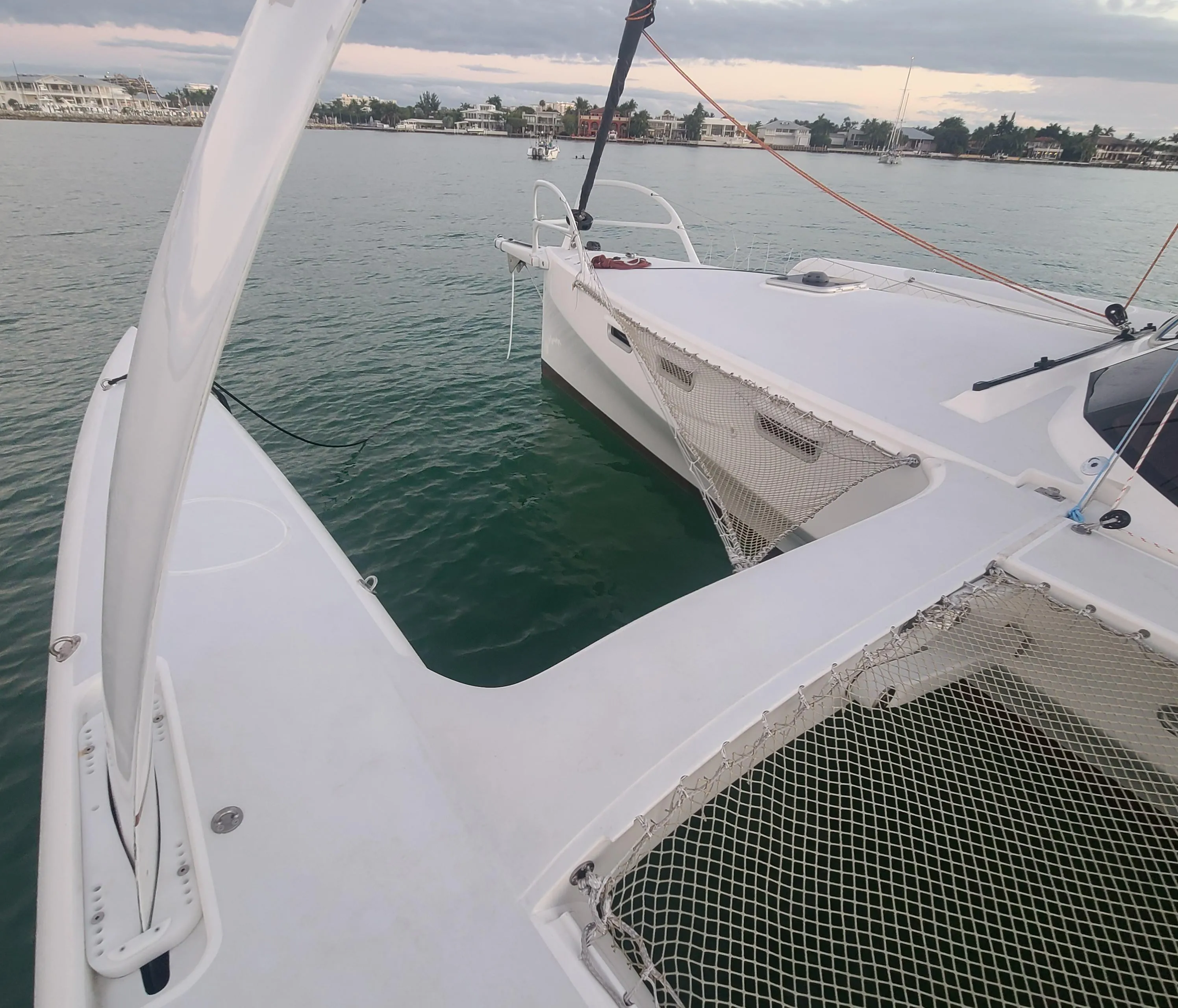 2025 Rapido 40 trimaran on calm water, showcasing sleek design and netted deck.