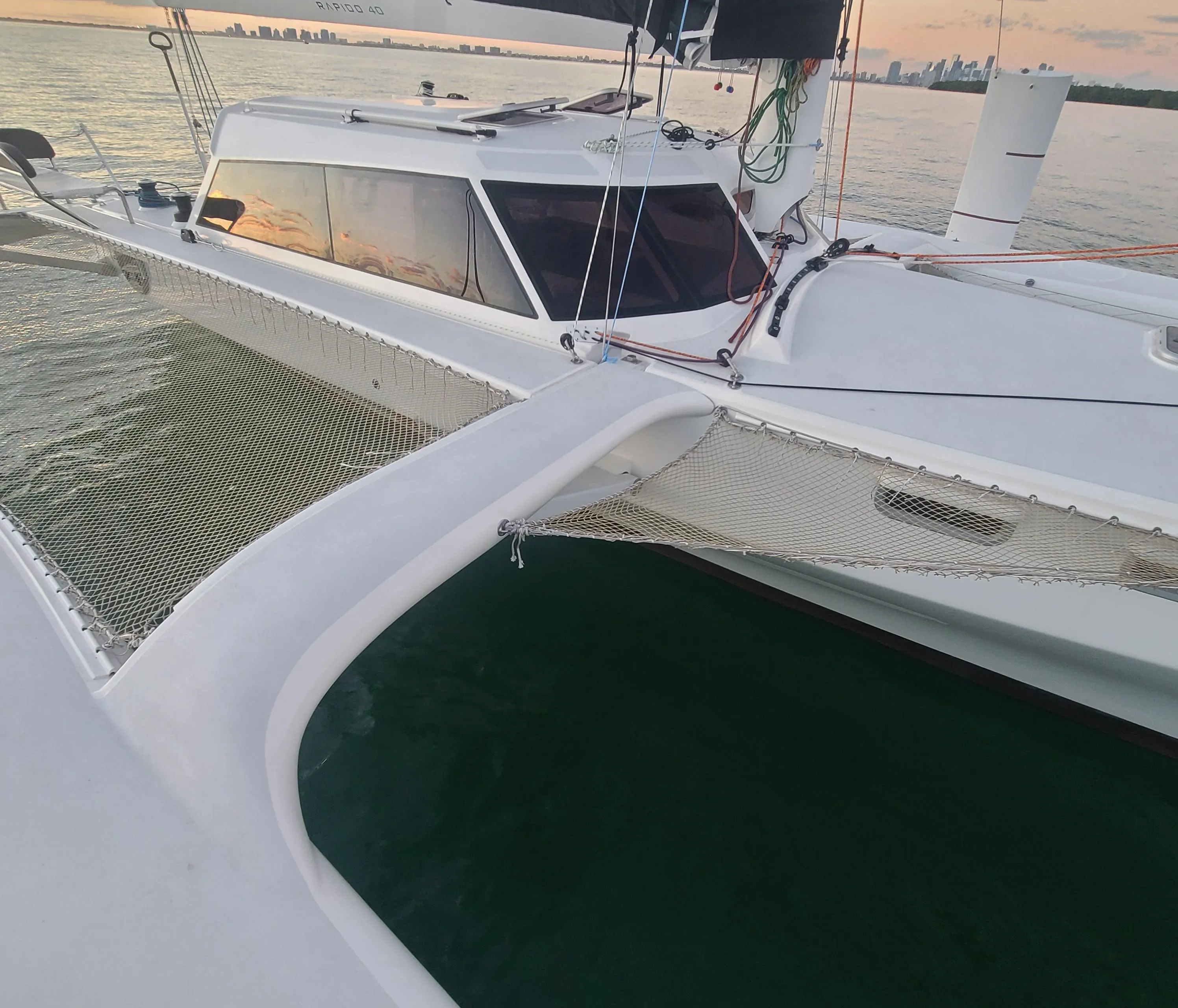 2025 Rapido 40 catamaran on calm water at sunset.