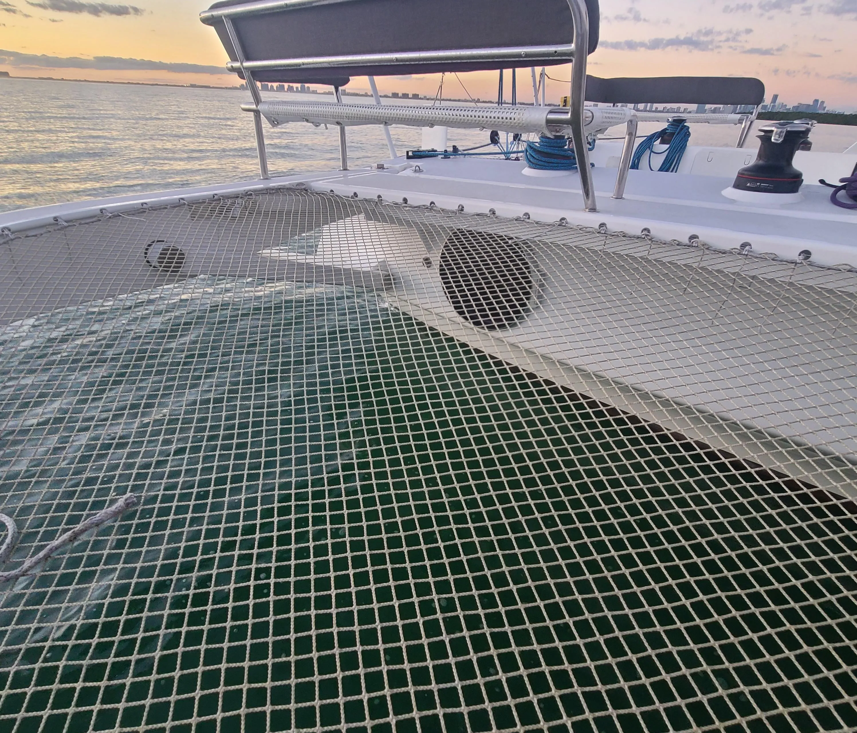 2025 Rapido 40 catamaran deck with netting, ocean view at sunset.