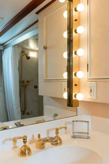 Seafari Yacht Photos Pics Luxurious bathroom on 1975 Burger Raised Pilothouse CPMY yacht with gold fixtures and vanity lighting.