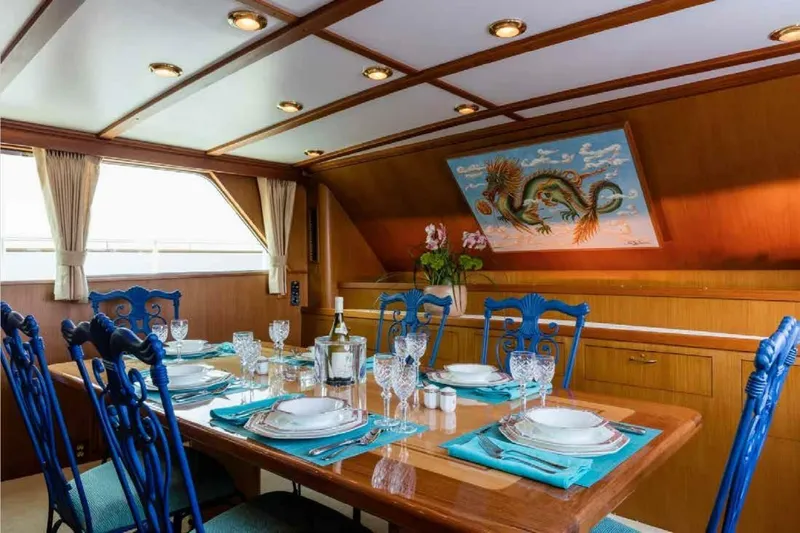 Seafari Yacht Photos Pics Luxurious dining area on 1975 Burger Raised Pilothouse CPMY yacht, featuring elegant table settings.