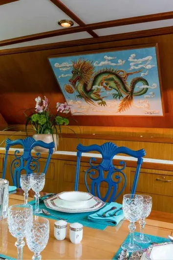 Seafari Yacht Photos Pics Elegant dining area on 1975 Burger Raised Pilothouse CPMY with dragon artwork and blue chairs.