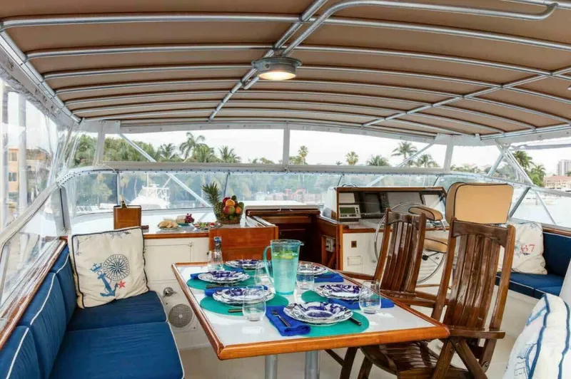 Seafari Yacht Photos Pics Interior of 1975 Burger Raised Pilothouse CPMY yacht with dining setup and scenic view.