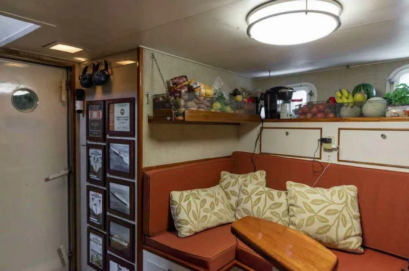 Seafari Yacht Photos Pics Cozy 1975 Burger Raised Pilothouse CPMY interior with seating, cushions, and fruit baskets.