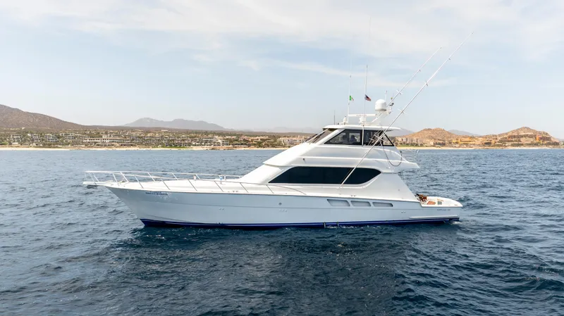 Strictly Business Yacht Photos Pics 2004 Hatteras 65 Enclosed Bridge yacht on open water, coastal landscape in background.