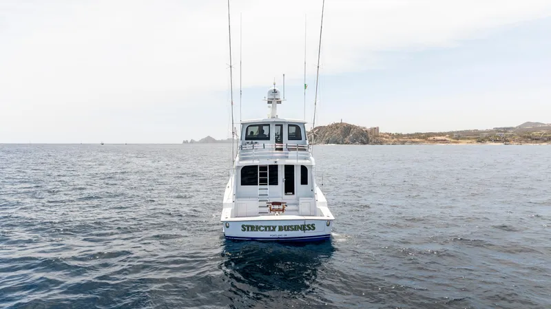 Strictly Business Yacht Photos Pics 2004 Hatteras 65 Enclosed Bridge yacht on open water, rear view.