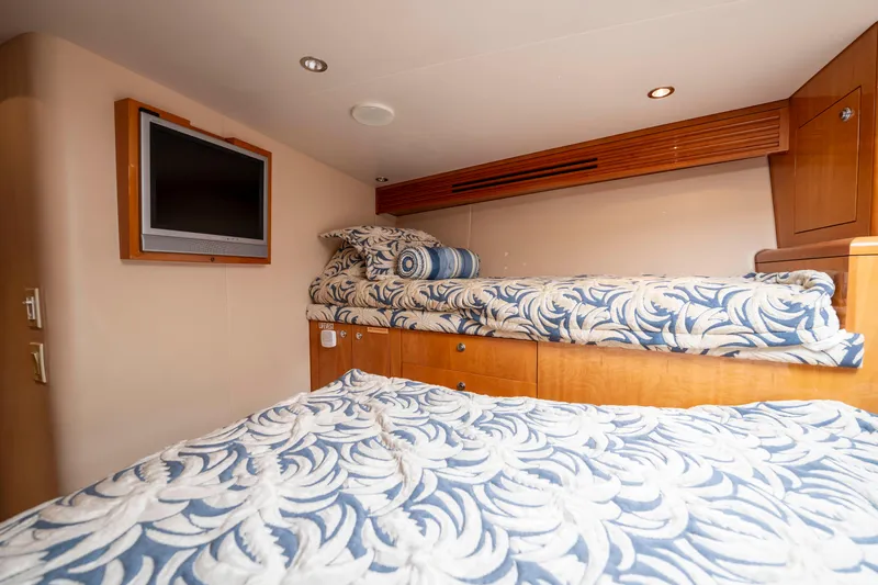 Strictly Business Yacht Photos Pics Interior of 2004 Hatteras 65 Enclosed Bridge with twin beds and wall-mounted TV.