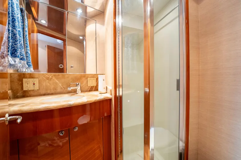 Strictly Business Yacht Photos Pics Luxurious bathroom in 2004 Hatteras 65 Enclosed Bridge yacht with wood accents and glass shower.