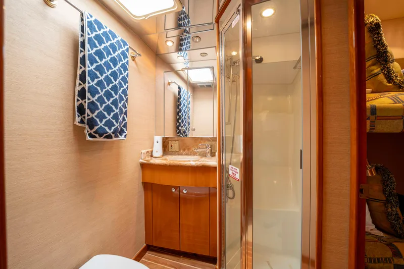 Strictly Business Yacht Photos Pics Luxurious bathroom in 2004 Hatteras 65 Enclosed Bridge yacht with modern fixtures.