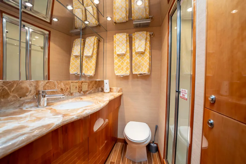 Strictly Business Yacht Photos Pics Luxurious bathroom in 2004 Hatteras 65 Enclosed Bridge yacht with marble countertop and wooden cabinetry.