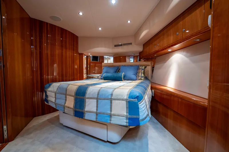 Strictly Business Yacht Photos Pics Luxurious bedroom interior of 2004 Hatteras 65 Enclosed Bridge yacht with wood paneling.