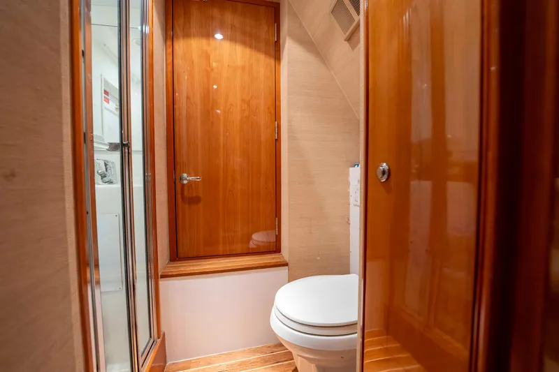 Strictly Business Yacht Photos Pics Luxurious bathroom on 2004 Hatteras 65 Enclosed Bridge yacht with wooden finishes.