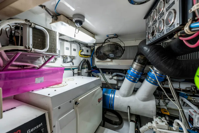 Strictly Business Yacht Photos Pics Engine room of 2004 Hatteras 65 Enclosed Bridge yacht, featuring equipment and ventilation systems.