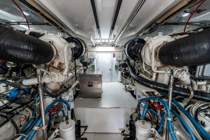 Strictly Business Yacht Photos Pics Engine room of 2004 Hatteras 65 Enclosed Bridge yacht, showcasing dual engines and mechanical systems.