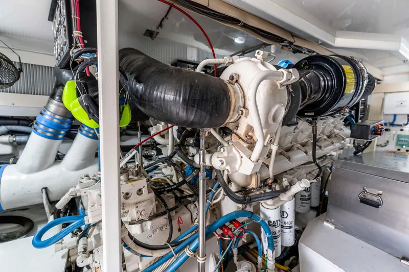 Strictly Business Yacht Photos Pics Engine room of 2004 Hatteras 65 Enclosed Bridge yacht, showcasing complex machinery and components.