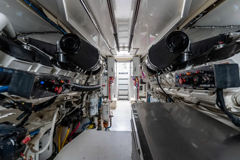 Strictly Business Yacht Photos Pics Engine room of 2004 Hatteras 65 Enclosed Bridge yacht, showcasing dual engines and equipment.