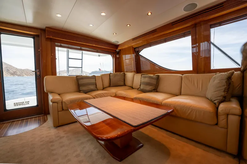 Strictly Business Yacht Photos Pics Luxurious interior of 2004 Hatteras 65 Enclosed Bridge yacht with plush seating and ocean view.
