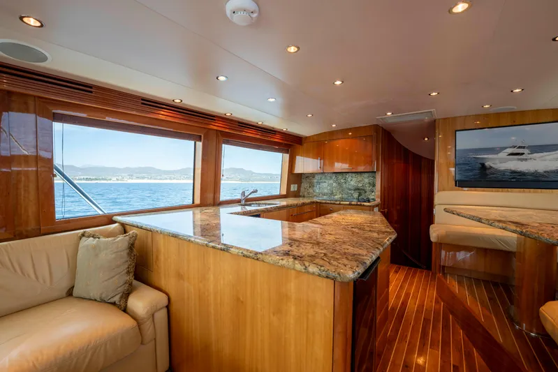 Strictly Business Yacht Photos Pics Luxurious interior of 2004 Hatteras 65 Enclosed Bridge yacht with wood finishes and ocean view.