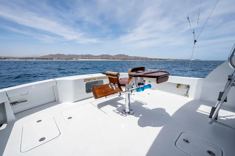 Strictly Business Yacht Photos Pics 2004 Hatteras 65 Enclosed Bridge yacht deck with fishing chair, ocean view.