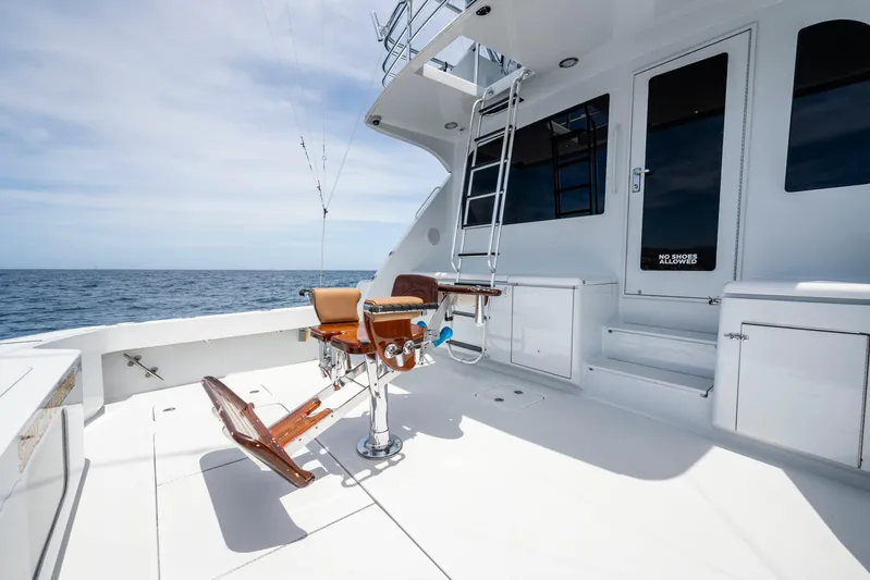 Strictly Business Yacht Photos Pics 2004 Hatteras 65 Enclosed Bridge yacht deck with fishing chair and ocean view.