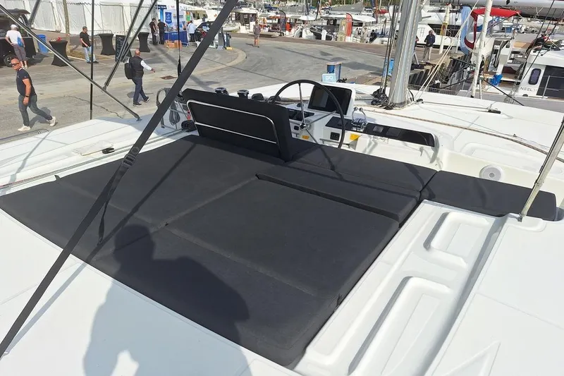 Yoff Yacht Photos Pics 2023 Lagoon 46 yacht deck with seating area at a marina.