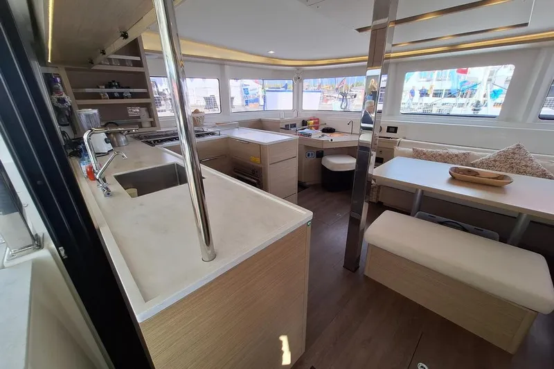 Yoff Yacht Photos Pics Modern interior of 2023 Lagoon 46 catamaran with kitchen and seating area.