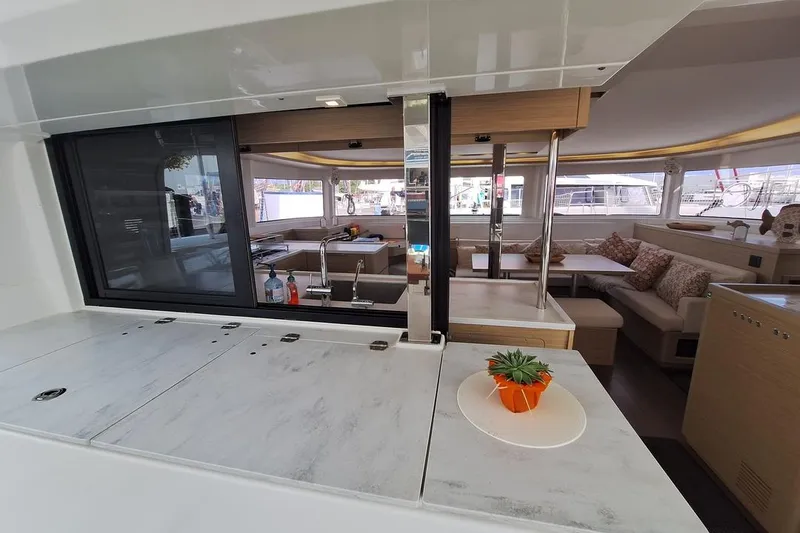 Yoff Yacht Photos Pics 2023 Lagoon 46 yacht interior with modern kitchen and cozy seating area.