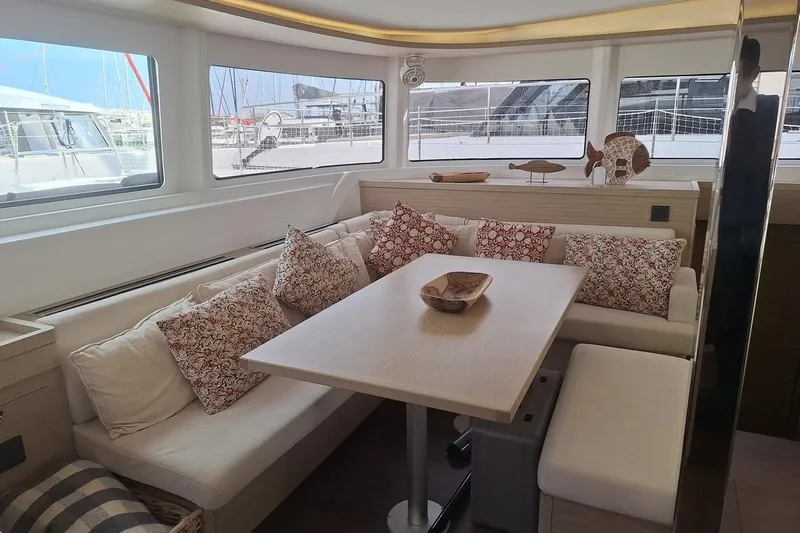Yoff Yacht Photos Pics Luxurious interior of 2023 Lagoon 46 catamaran with cozy seating and decorative pillows.