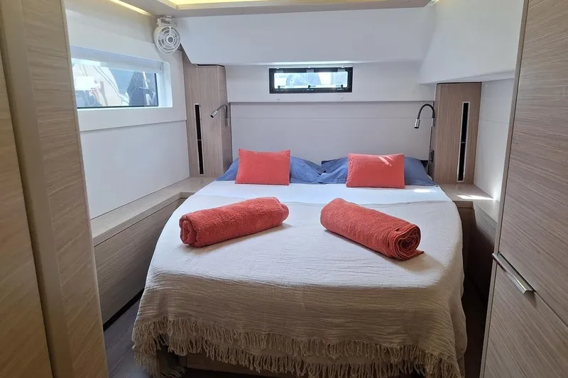 Yoff Yacht Photos Pics Luxurious cabin interior of 2023 Lagoon 46 yacht with cozy bed and vibrant decor.