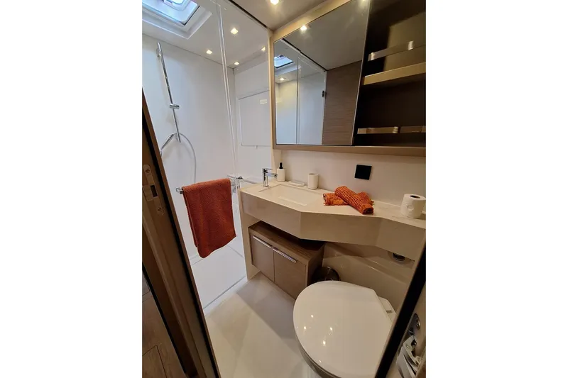 Yoff Yacht Photos Pics Modern bathroom in 2023 Lagoon 46 yacht with shower, sink, and toilet.